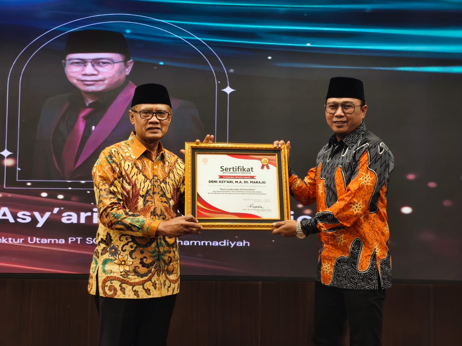 Haedar Nashir menyerahkan penghargaan Best Leadership of Innovation kepada Deni Asy'ari dalam Malam Tasyakuran Milad ke-110 Suara Muhammadiyah. Foto: Cris
