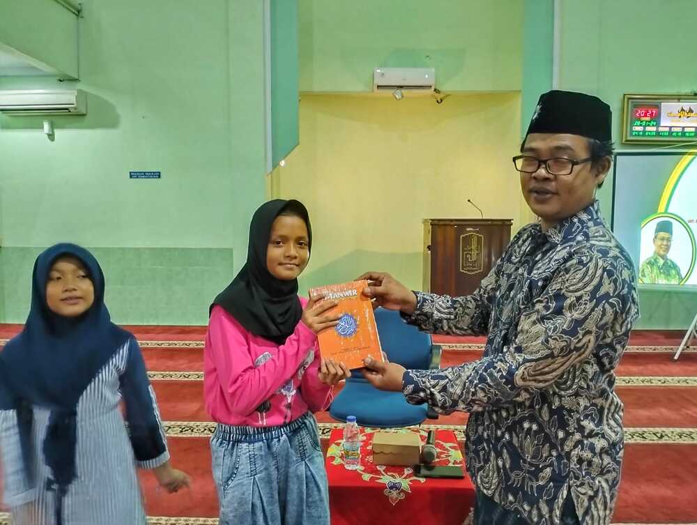 Penyerahan Hibah Al-Qur'an oleh Ketua Takmir Masjid Al-Amien Muarif, SPdI., MPd kepada perwakilan Majelis Dzikir Al-Amien. Doc. SM